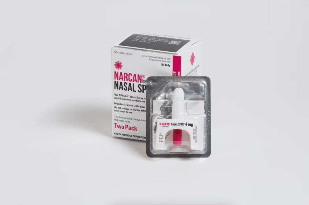 Photo of Narcan nasal spray box and applicator in front of white background