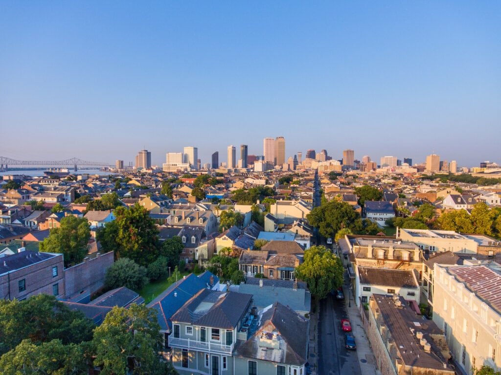 Aerial view of New Orleans skyline with residential neighborhoods in foreground.