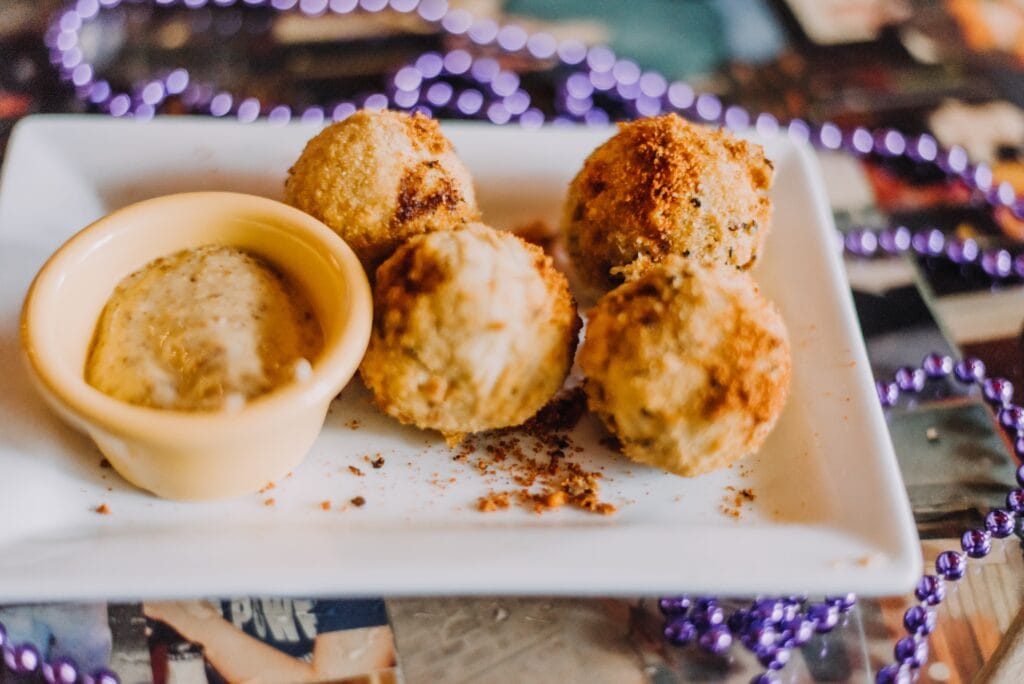 Cheese balls with dipping sauce on a white plate for NOLA Detox.